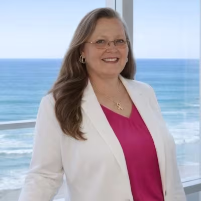headshot of Jill Bumgarner, wearing a white blazer with a pink shirt