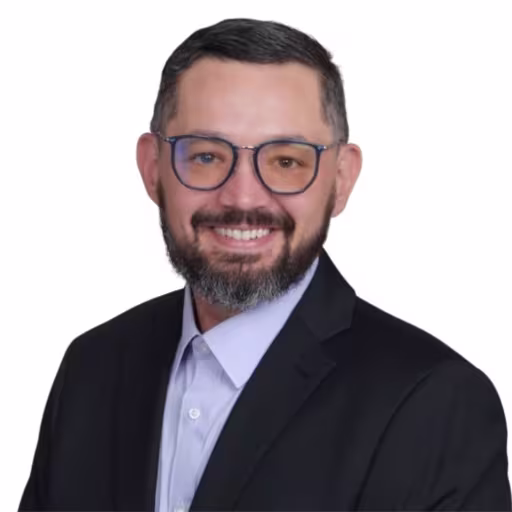 headshot of Aaron Hermosillo, wearing a black suit with a light blue shirt