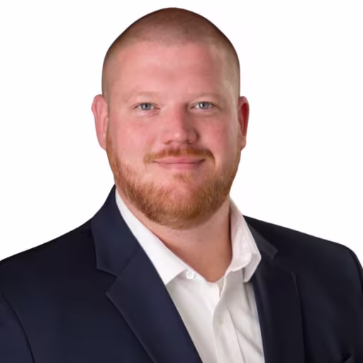 headshot of Adam Goode, wearing a black suit and white shirt