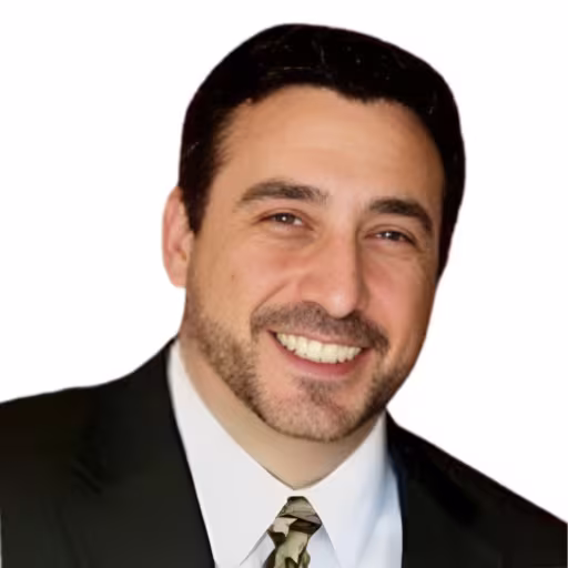 headshot of Alan Sanders, wearing a black suit and a white shirt