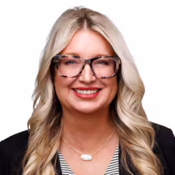headshot of Amber O'Rear, wearing a black blazer and striped shirt