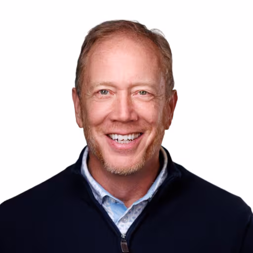 headshot of Andy Mears, wearing a dark blue sweater with a light blue shirt