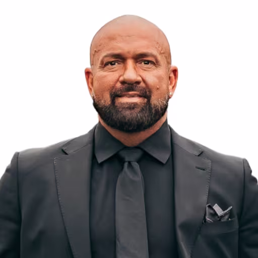 Headshot of Andy Toth wearing black dress shirt, black tie, and black suit coat with white background