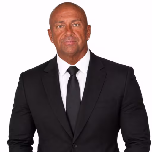 Headshot of Andy Toth, wearing a black suit with a white shirt and black tie