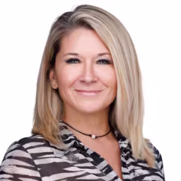 headshot of Angela Crutchfield, wearing a stripped blouse