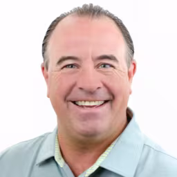 headshot of Mike Behrens, wearing a light green polo