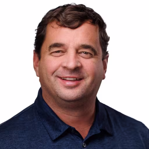 headshot of Bill Bader, wearing a dark blue polo