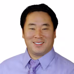 headshot of Brent Hauger, wearing a purple shirt and tie