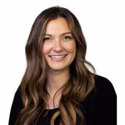 Headshot of Brooke Hines wearing black long sleeved shirt with white background