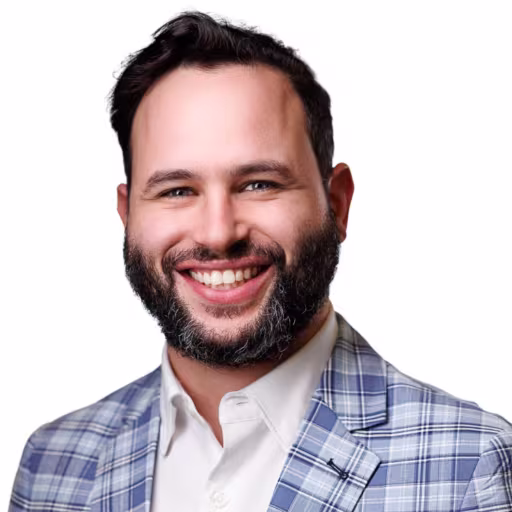 headshot of Carlos Wejebe, wearing a blue, plaid suit