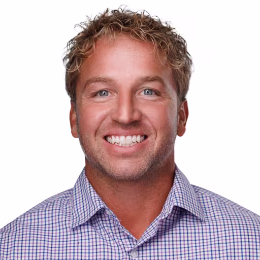 Headshot of Chad Seeling wearing white, blue, and purple checkered shirt with white background