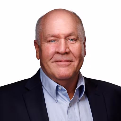 headshot of Chuck Burks, wearing a black suit and blue shirt