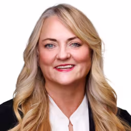 headshot of Dede Hanka, wearing a black suit with a white blouse