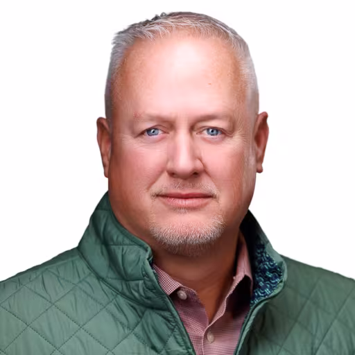 headshot of Dwight Bennett, wearing a green vest