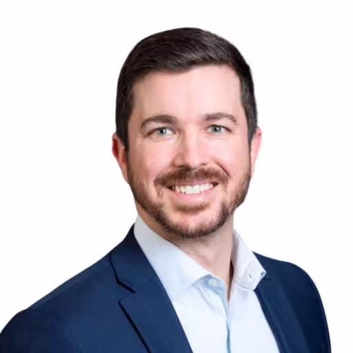 Headshot of Eric Reed, wearing a blue suit and a light blue shirt