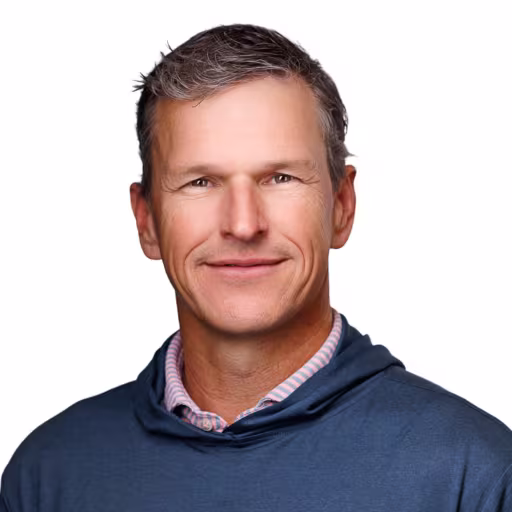 headshot of George Linney, wearing a dark blue sweater with a purple shirt.