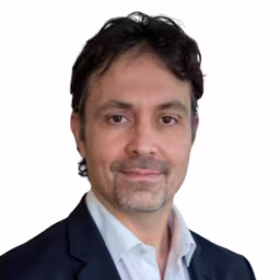 headshot of Gregg Pomeroy, weaing a black suit with a white shirt