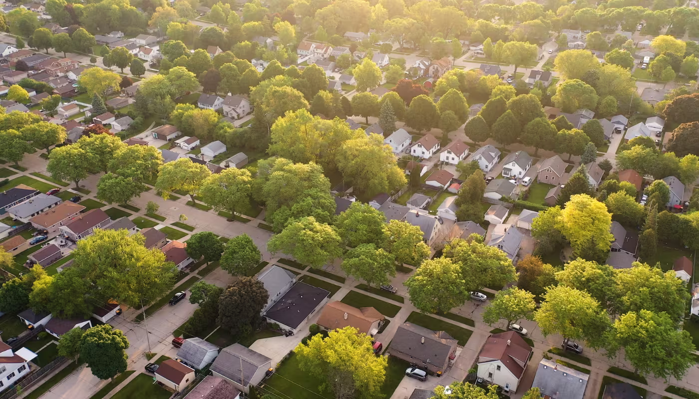 Aerial view of american suburb at summertime. Establishing shot of american neighborhood. Real estate, residential houses. Drone shot, from above