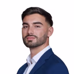 headshot of Ishmael Patino, wearing a blue suit and white shirt