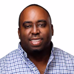 headshot of JeRon Allen, wearing a blue and white plaid shirt