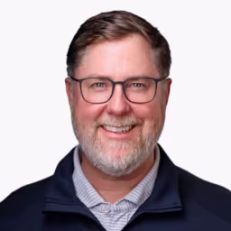 headshot of Jeff Gilmore, wearing a dark blue sweater with a light blue shirt