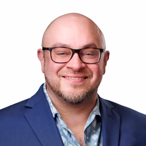 headshot of Jesse Mutarelli, wearing a blue suit
