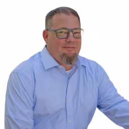 Headshot of Jimi Nelson wearing light blue dress shirt with white background