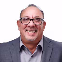 headshot of Joe DeVito, wearing a grey suit and grey shirt