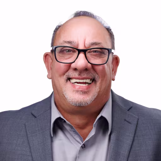 headshot of Joe DeVito, wearing a grey suit and grey shirt
