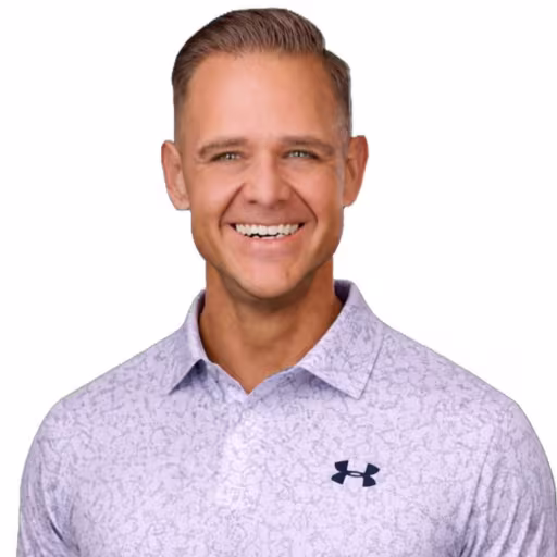 headshot of John Rudolph, wearing a purple patterned polo