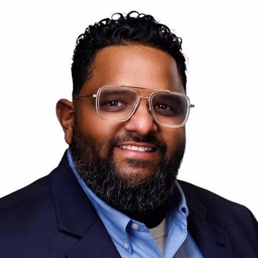 headshot of Jose Brador, wearing a dark blue suit with a light blue shirt