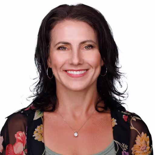Headshot of Julie Galli wearing sage green under shirt and black floral blouse with white background