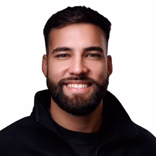 Headshot of Kevin Garcia wearing black shirt and black zip up with white background