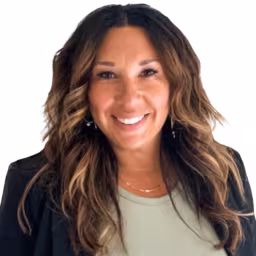 headshot of Kristina Neapolitan, wearing a green shirt and black blazer