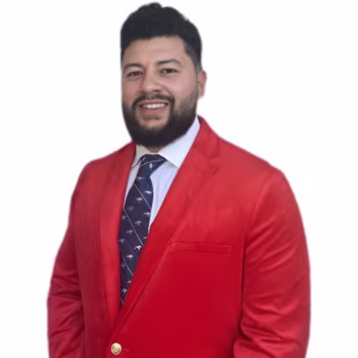 headshot of Luis Hernandez, wearing a red suit with a blue tie