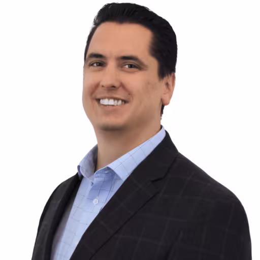 Headshot of Luke Pickel wearing light blue dress shirt and black suit coat with white background