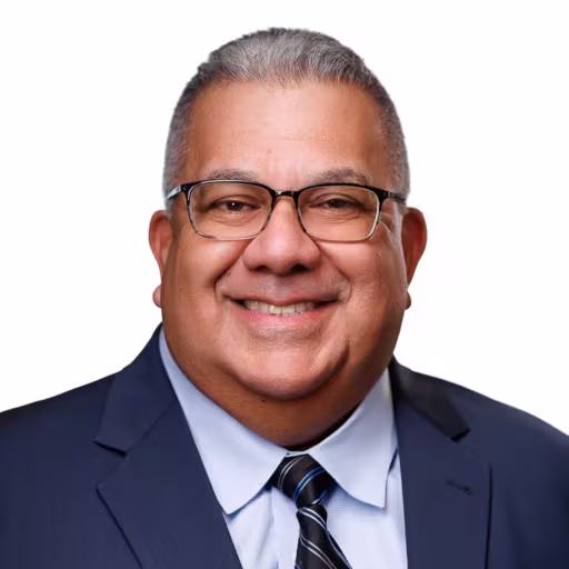 headshot of Marco Soriano, wearing a dark blue suit with a blue tie