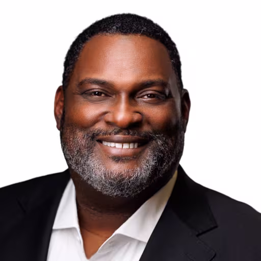 Headshot of Martez Coleman wearing white dress shirt and black suit coat with white background