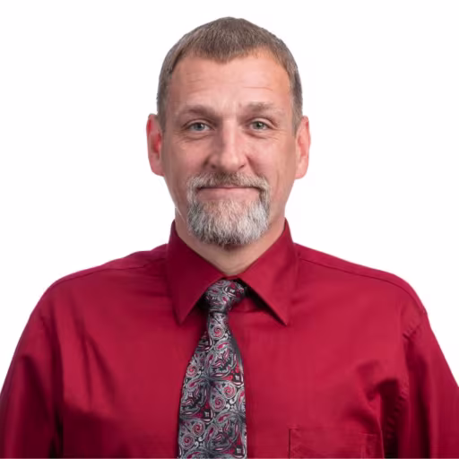 headshot of Matthew Yakich, wearing a red button up with a patterned tie