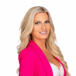 headshot of Megan Winslow, wearing a bright pink blazer and white shirt
