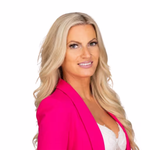 headshot of Megan Winslow, wearing a bright pink blazer and white shirt