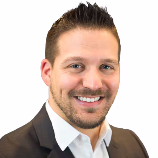 headshot of Nick Zajaczkowski, wearing a brown suit jacket and white shirt
