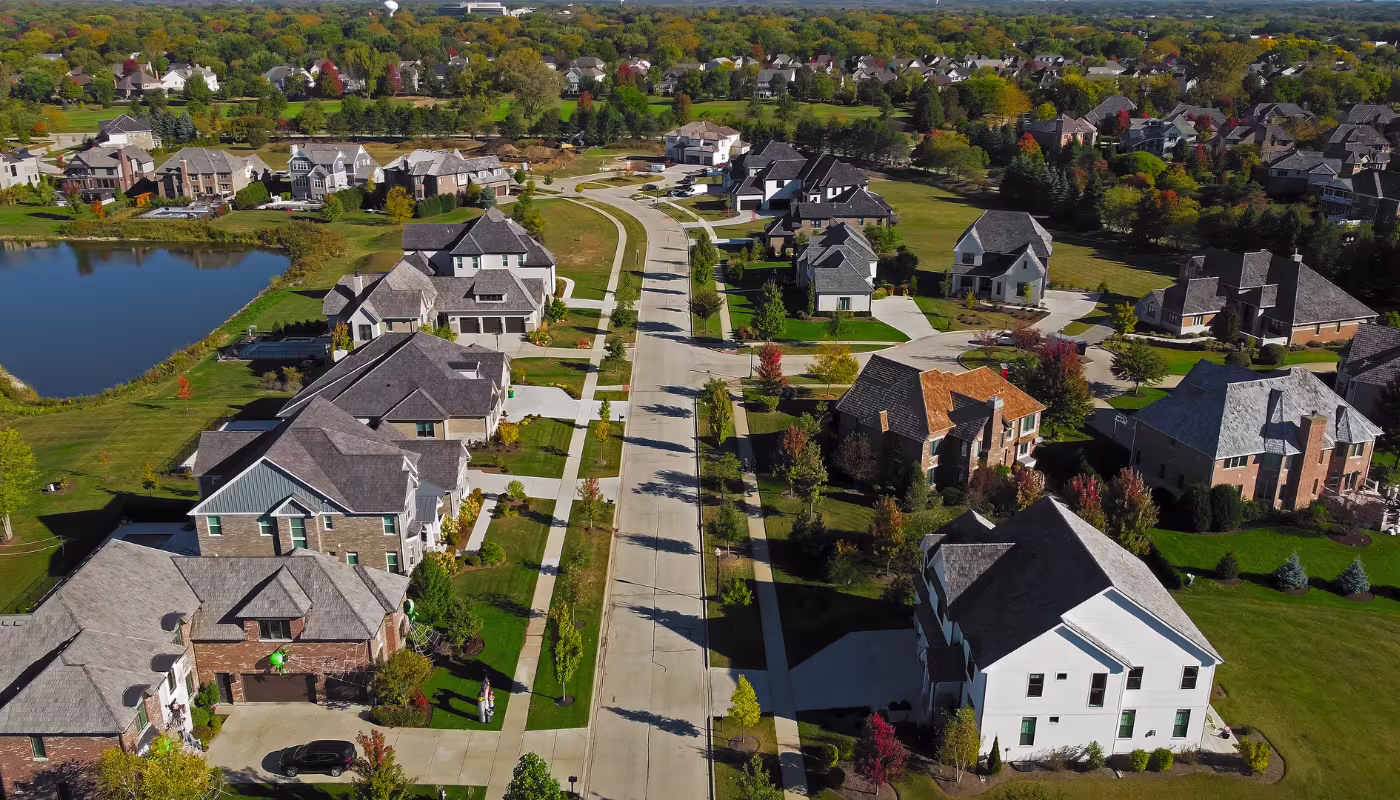 Aerial view of suburban neighborhood in Chicago, Illinois. A scenic aerial view of a suburban neighborhood in Chicago, Illinois, featuring large homes with manicured lawns.