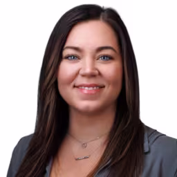 Headshot of Rachael Schaaf wearing grey dress shirt with white background