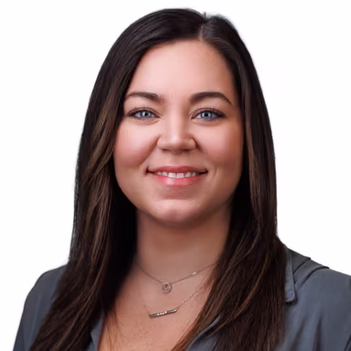 Headshot of Rachael Schaaf wearing grey dress shirt with white background