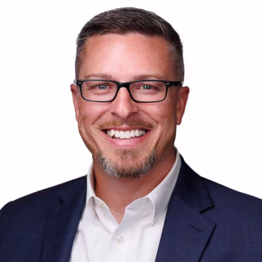 headshot of Ray Tweedie, wearing a dark blue suit and white shirt