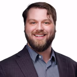 headshot of Richard Bellows, wearing a grey suit with a light grey shirt