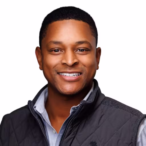 headshot of Ross Rhodes, wearing a grey vest with a light blue shirt