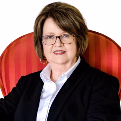 headshot of Sara Kidd, wearing a black suit with a white shirt