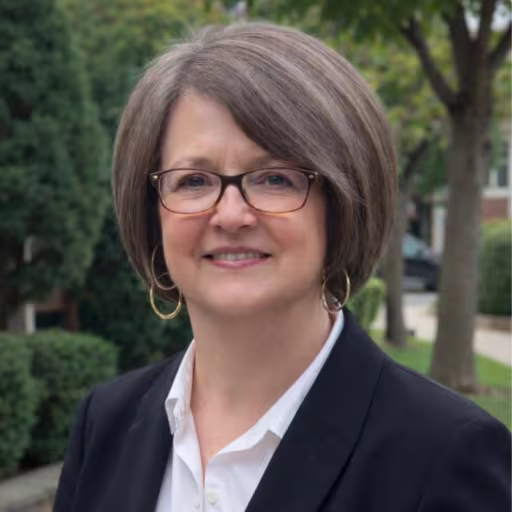 headshot of Sara Kidd, wearing a black blazer with a white shirt